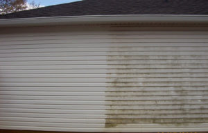 pressure washing siding on a house